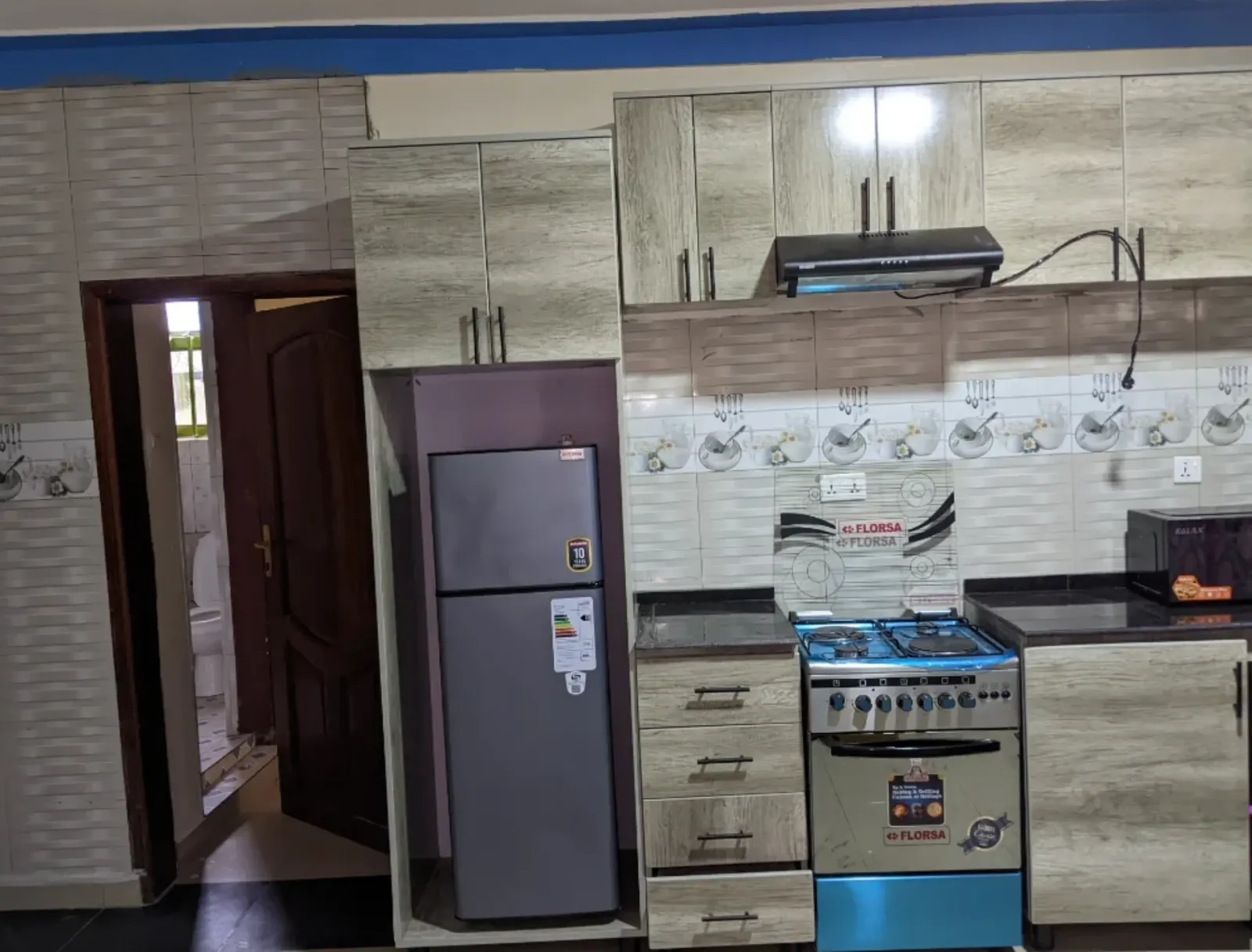 The kitchen, with fridge, cooker and extractor