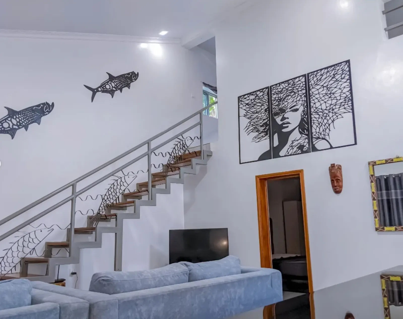The double-height living room, with the staircase and wall art