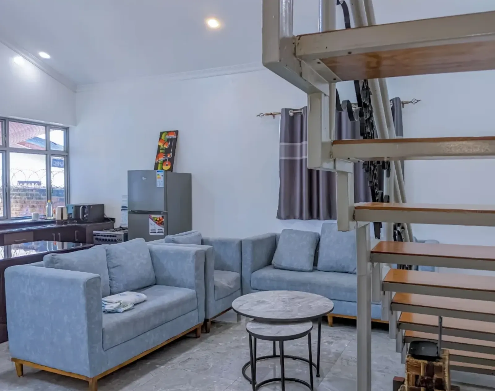 The living room, open to the kitchen behind it